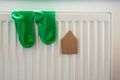 Paper house and pair of green socks on the white radiator.