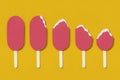 Paper ice-cream on yellow background in different stages of eating.