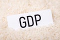 Paper with inscription GDP on grain of rice