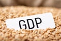 Paper with inscription GDP on wheat grain