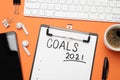 Paper with inscription 2021 Goals, new year items. Objects on orange background, flat lay Royalty Free Stock Photo