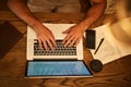 That paper isnt going to write itself. High angle shot of an unidentifiable young student using his laptop to study at a Royalty Free Stock Photo