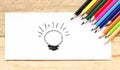 Paper ,Light bulb idea and color pencils on wooden table Royalty Free Stock Photo