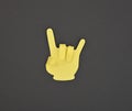 Paper made yellow HORNS gesture sticker on grey