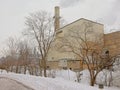 Paper manufactoring plant in the snow behind bare trees in Gatineau Royalty Free Stock Photo