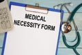 Paper with Medical necessity form on a table, stethoscope and calculator Royalty Free Stock Photo