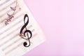 Paper musical clef on a sheet of music and dried flowers. Top view