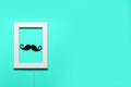 Paper mustache and a notepad on blue background. Royalty Free Stock Photo