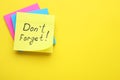 Paper note with phrase Don` t Forget on yellow background, top view. Space for text Royalty Free Stock Photo