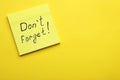 Paper note with phrase Don\' t Forget on yellow background, top view. Space for text Royalty Free Stock Photo