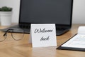 Paper note with phrase Welcome Back on office desk Royalty Free Stock Photo