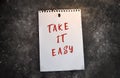 Paper note with TAKE IT EASY written on black slate board Royalty Free Stock Photo