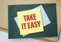Paper note with TAKE IT EASY written on black Royalty Free Stock Photo
