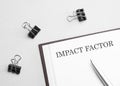 paper note with text IMPACT FACTOR, pen and office tools, white background. business concept Royalty Free Stock Photo
