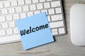 Paper note with word Welcome on computer keyboard, top view Royalty Free Stock Photo