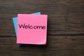 Paper note with word Welcome on wooden table, top view. Space for text Royalty Free Stock Photo