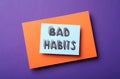 Paper note with words Bad Habits on purple background, top view Royalty Free Stock Photo