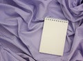 Paper notebook with an empty cover on a purple-striped tablecloth Royalty Free Stock Photo