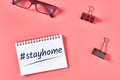 Paper notebook with hashtag near binder and modern glasses on pink desk