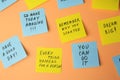 Paper notes with life-affirming phrases on pale orange background