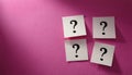 Paper notes with question marks on pink background, flat lay. Space for text Royalty Free Stock Photo