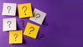 Paper notes with question marks on Violet background, flat lay. Space for text Royalty Free Stock Photo