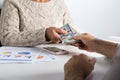 Paper notes from USA. Dollar. Person handing over bills to another business woman