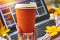 Paper orange coffee cup mock up close up. Autumn atmosphere. Vertical photo