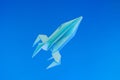 Paper origami rocket flies on a blue background. Space concept.