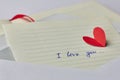 Paper page of notebook with sign I love you and red paper heart in envelope Royalty Free Stock Photo