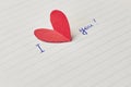Paper page of notepad with sign I love you and red paper heart