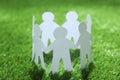 Paper people chain making circle on green grass. Unity concept Royalty Free Stock Photo