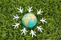 Paper people in a circle with green grass background Royalty Free Stock Photo