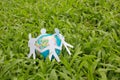 Paper people in a circle with green grass background Royalty Free Stock Photo