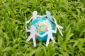 Paper people in a circle with green grass background Royalty Free Stock Photo