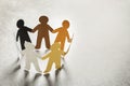 Paper people holding hands on light background Royalty Free Stock Photo