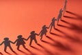 Paper people holding hands on red surface. Community, union concept. Society and support. Royalty Free Stock Photo
