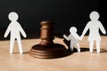 Paper people near wooden gavel on black Royalty Free Stock Photo