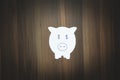 Paper piggy bank on the wooden background