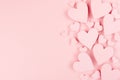 Paper pink hearts fly on soft pink color background, border, copy space. Valentine day concept for design. Royalty Free Stock Photo