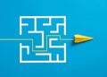 Paper plane breaking through the maze on blue background Royalty Free Stock Photo
