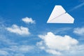 Paper plane flying over clouds with blue sky. Royalty Free Stock Photo