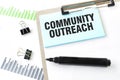 Paper plate, marker, diagram, chart and office tools. Text COMMUNITY OUTREACH Royalty Free Stock Photo