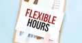 Paper plate with text FLEXIBLE HOURS. Diagram, notepad and blue background Royalty Free Stock Photo