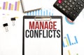 Paper plate with text MANAGE CONFLICTS. Diagram, calculator, notepad and white background Royalty Free Stock Photo