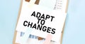 Paper plate with text take ADAPT TO CHANGES. Diagram, notepad and blue background Royalty Free Stock Photo
