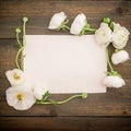 Paper post card and white flowers on wooded background. Flat lay, top view. Vintage background. Royalty Free Stock Photo