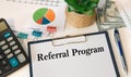 Paper with Referral Program on the table calculator and money