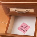 Paper reminder in open desk drawer