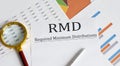 Paper with Required Minimum Distributions RMD on a table with pen ,chart , magnifier Royalty Free Stock Photo